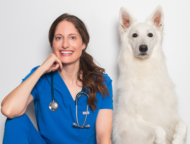 Dr. Rachel Malamed in blue scrubs with Luna, a white shepherd